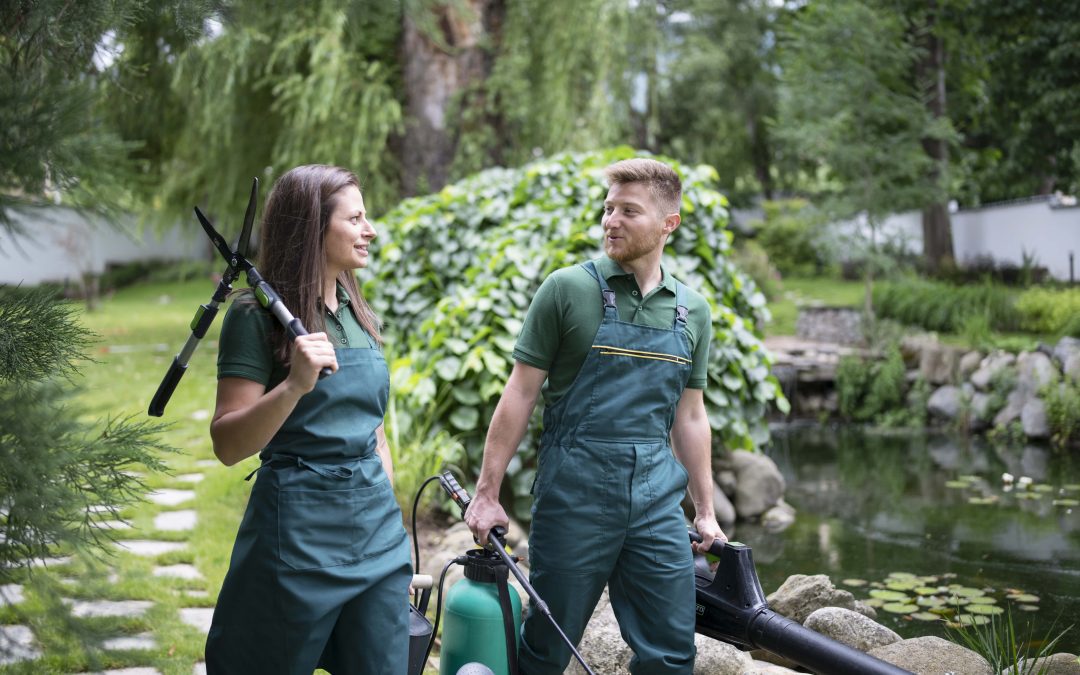 Man and woman are walking in garden and carrying gardening equipment.